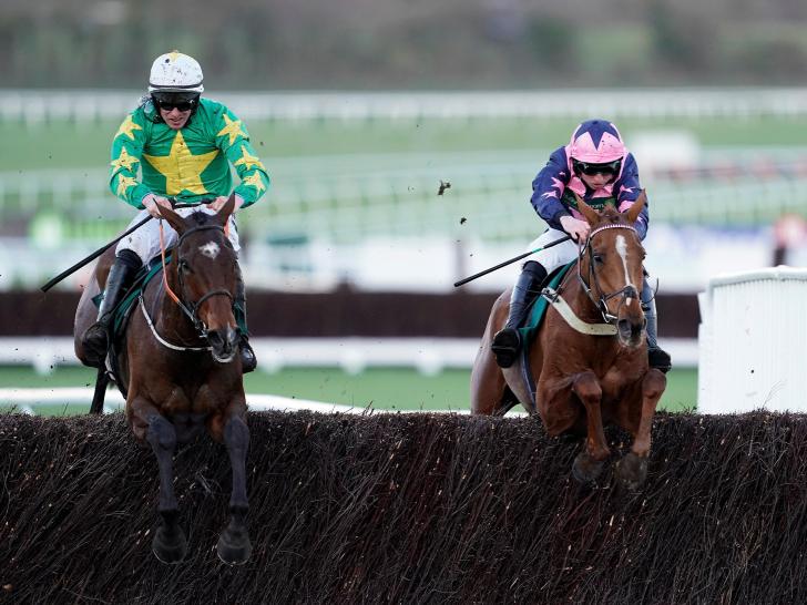 Horses jumping fence